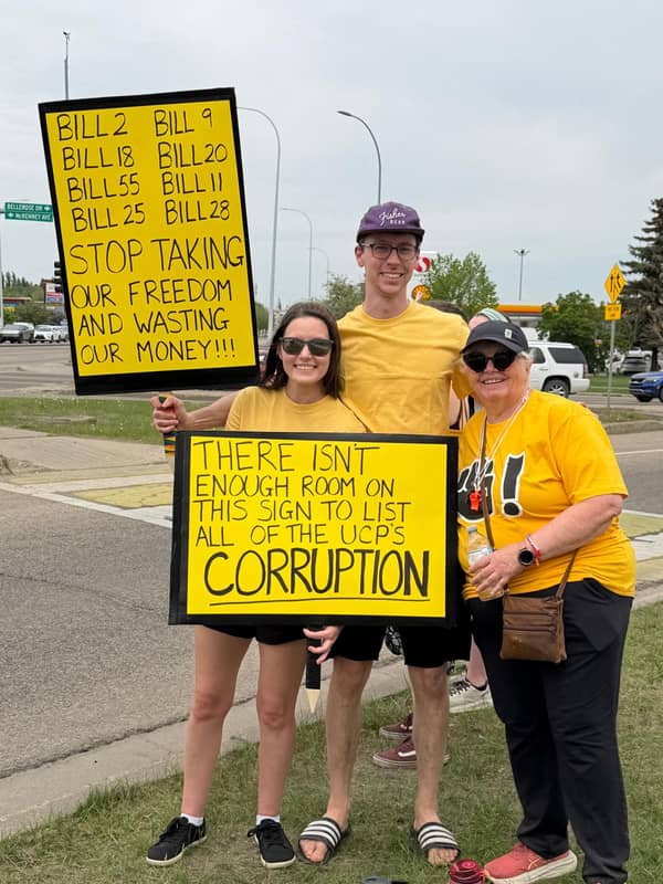 Family holding hand-painted signs